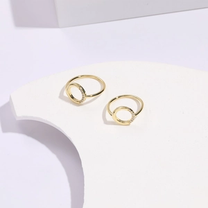 Detailed macro view of two minimalist 14k gold plated geometric rings with white zircons