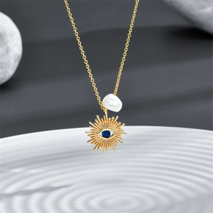 14k gold plated brass evil eye necklace featuring a freshwater pearl and blue zircon pendant