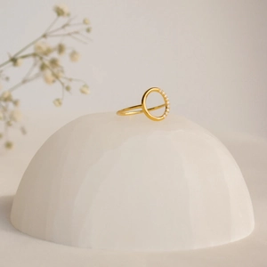 Detailed view of a 14k gold plated round ring with cubic zirconia on stone base