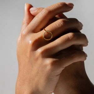 Elegant 14K gold plated brass ring with round zirconia stones on a model's hand