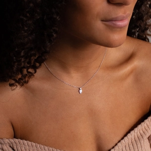 Close-up of 14k gold plated water drop necklace with sparkling zircon on a model