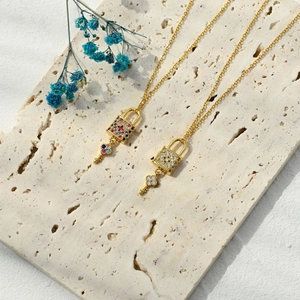 Detailed close-up of 14k gold plated heart lock pendants with colorful zircon inlay