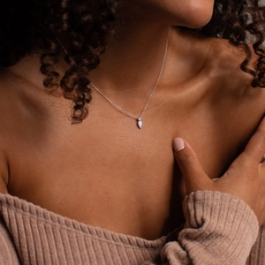 Detail of 14k gold plated teardrop necklace with zircon stone on a female model