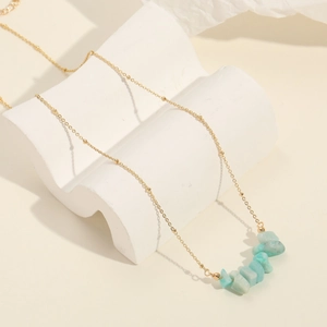 Minimalist 14k gold plated necklace featuring natural light blue stones on white display