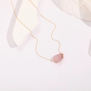 Minimalist 14k gold plated necklace with raw natural rose quartz pendant on white background
