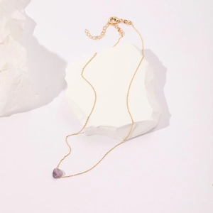 Detail of a purple heart gemstone pendant on a gold adjustable necklace chain