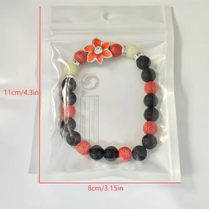 Bracelet fleuri lumineux avec pierre volcanique noire et perles rouges emballé