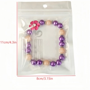 Detailed size view of glowing beaded bracelet with pink sunflower charm in packaging