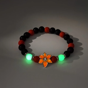 Vue macro des perles lumineuses et du pendentif fleur sur un bracelet en pierre volcanique
