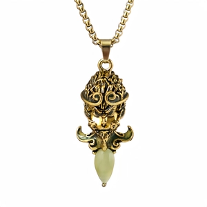 Vue détaillée du pendentif doré Sun Wukong avec pierre verte sur un fond blanc neutre