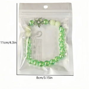 Bracelet cerisier lumineux avec perles vertes et breloque fleurie sous sachet