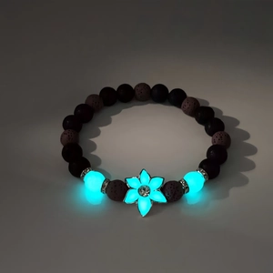 Détail macro du pendentif fleur bleue lumineuse avec perles sur bracelet en pierre de lave