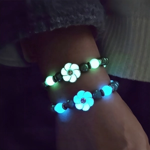 Luminous sunflower bead bracelets glowing in bright green and ice blue in the dark