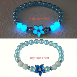 Bracelet perlé bleu lumineux avec breloque fleur montrant l'effet jour et nuit