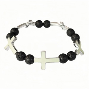 Detailed macro view of elastic bracelet featuring black lava beads and silver crosses