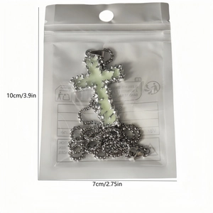 Vue détaillée du pendentif croix lumineux avec texture métal liquide sous emballage