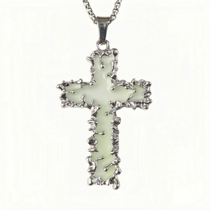 Vue détaillée du pendentif croix argentée avec insert lumineux et texture lave