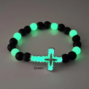 Détail du pendentif croix lumineuse verte sur bracelet religieux en pierre naturelle