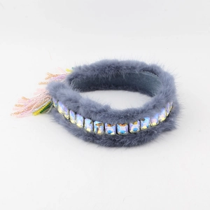Detailed view of gray faux fur headband with crystal inlay and beaded fringe accents