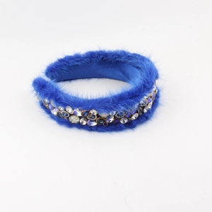 Detailed macro view of royal blue plush headband with sparkling rhinestones and gems