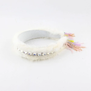 Detailed view of white mink fur headband with sparkling crystals and colorful beaded fringe