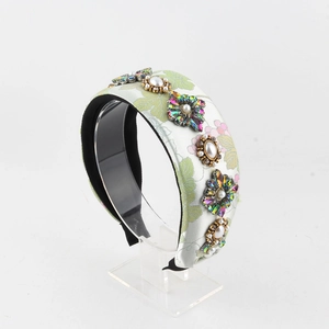 Détail d'un serre-tête large à fleurs avec ornements de strass colorés et perles