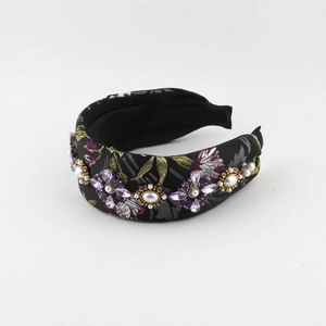 Détail du serre-tête vintage montrant la broderie florale et la fleur perlée ornée