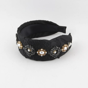 Détail d'un serre-tête noir vintage orné de fleurs complexes en perles et cristaux noirs