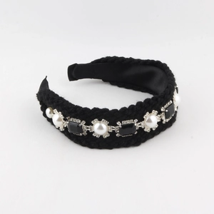 Détail d'un serre-tête baroque avec perles et pierres noires sur tissu en tricot noir