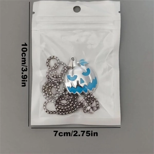 Detail of Halloween pumpkin charm pendant in packaging showing size 10cm by 7cm