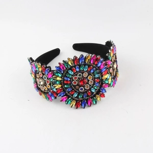 Detailed view of colorful rhinestones in a floral pattern on a wide velvet headband