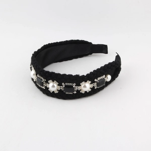 Détail d'un serre-tête en maille noire avec perles baroques et pierres précieuses