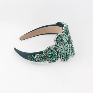 Détail macro des cristaux vert émeraude et strass sur le serre-tête baroque de style rétro