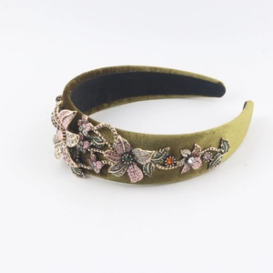Macro view of olive green velvet headband with baroque crystal flower embroidery