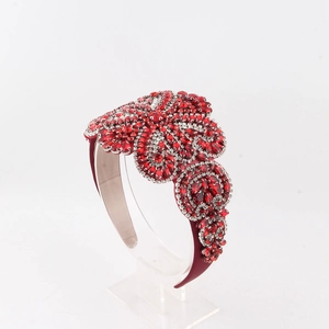 Vue détaillée du serre-tête baroque avec cristaux rouges et motifs floraux en strass