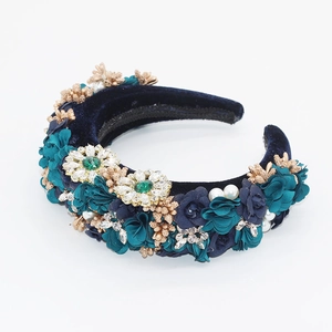 Détail du serre-tête en velours bleu marine avec fleurs en soie, perles et strass verts