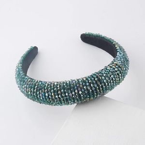Detail of green crystal beads on a padded sponge headband with black velvet lining