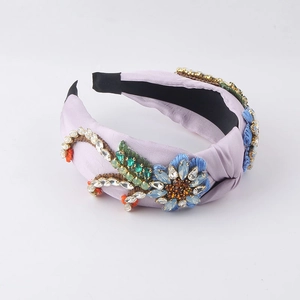 Detailed top view of light purple baroque headband with blue floral embroidery and crystals