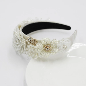 Serre-tête élégant en perles faites main avec strass champagne sur plateau blanc