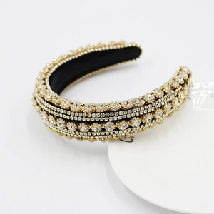 Close-up of luxury baroque headband with white rhinestones on golden alloy base