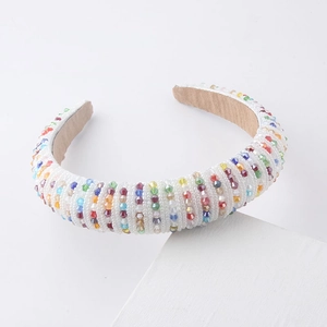 Detail of colorful beads on white padded headband with soft brown velvet lining