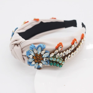Detail of baroque knotted headband with colorful crystals and floral embroidery