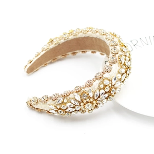 Macro shot of luxury baroque headband with crystals and pearls on beige satin