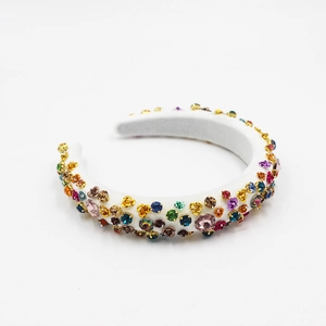Close-up of baroque white sponge headband with colorful rhinestones and metal claw settings