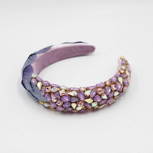 Détail du serre-tête baroque aux strass violets sur une doublure en velours mauve