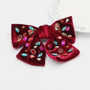 Détail de la barrette nœud en velours bordeaux avec strass multicolores et perles