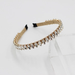 Detail of slim gold metal headband featuring marquee-cut rhinestones on acrylic stand