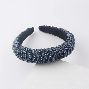 Close-up of deep blue faceted beadwork on thick headband with black velvet inner lining