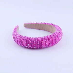 Detail eines handgefertigten rosa Haarreifs mit Kristallperlen und Wildlederfutter