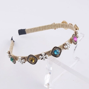 Detail of gold woven headband with multi-color gemstones and faux pearl flower motifs
